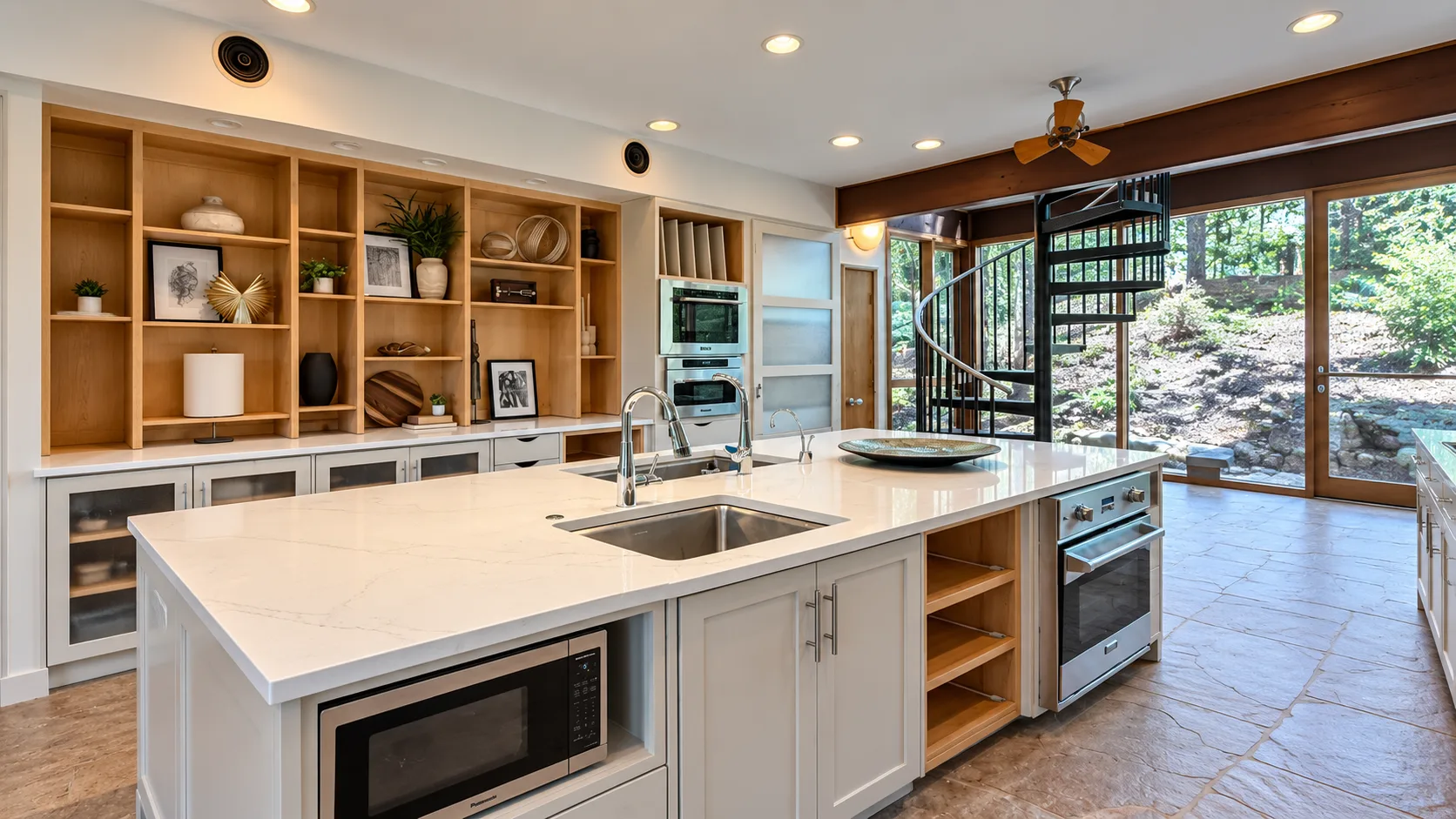 The same kitchen after renovation, with open wood shelving, white cabinetry and a large white stone island